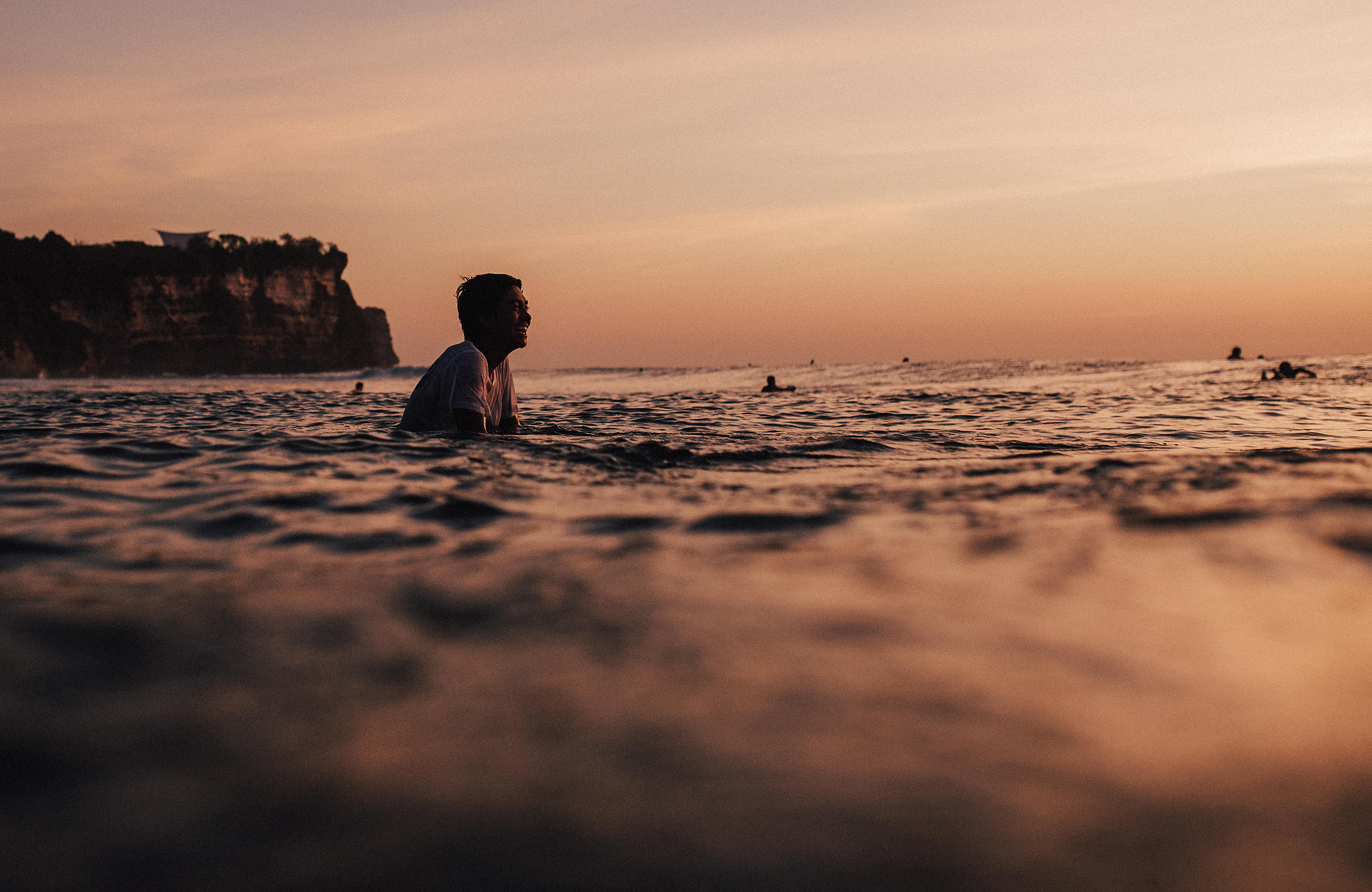 Chillen op een surfplank in het water in Uluwatu, Bali | KILROY