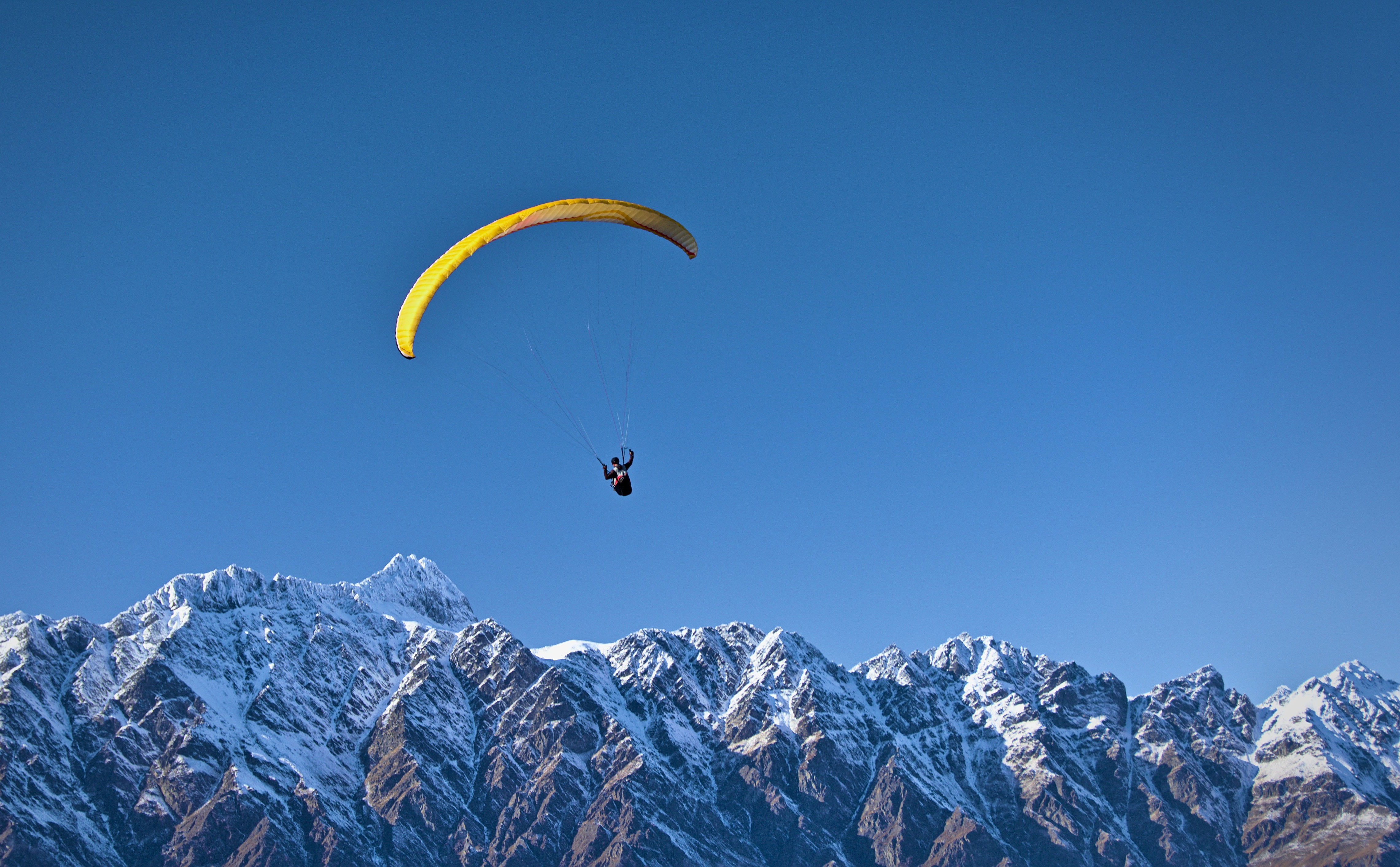 Paragliding over de besneeuwde bergtoppen bij Queenstown in Nieuw-Zeeland
