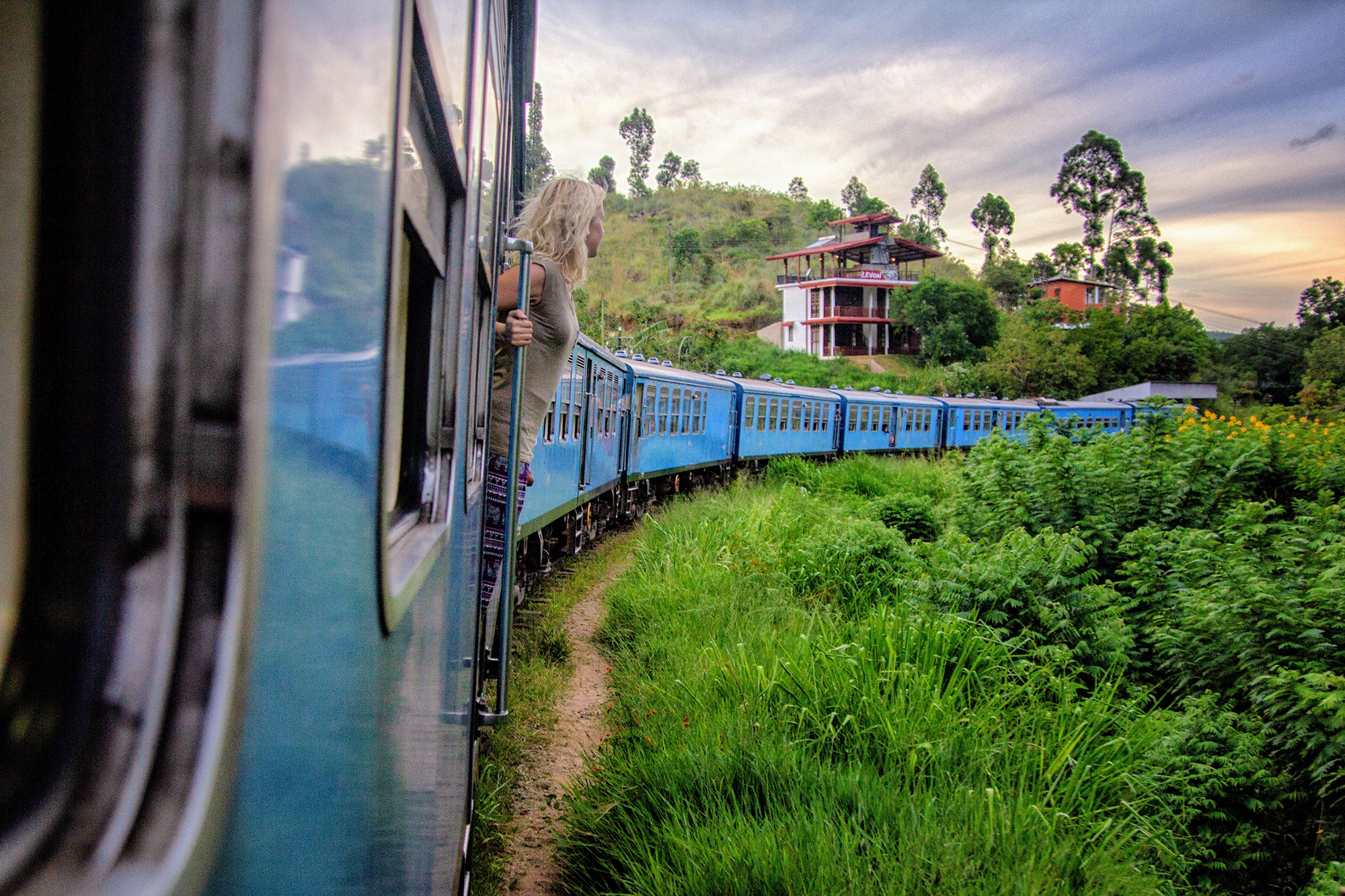 Meisje hangt uit de trein in Ella in Sri Lanka
