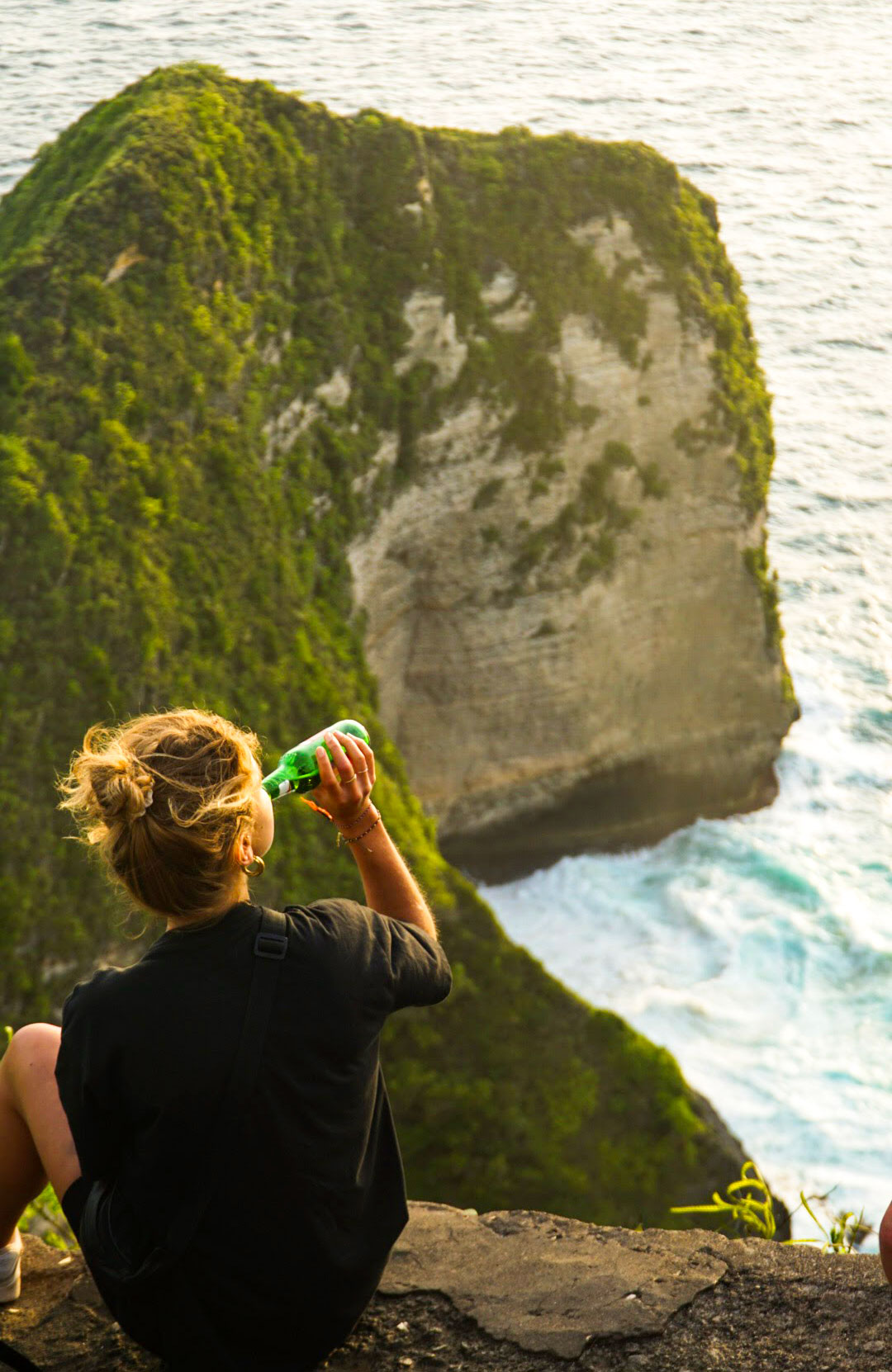 Amarins Drinking A Beer On A Cliff, Overlooking The Ocean