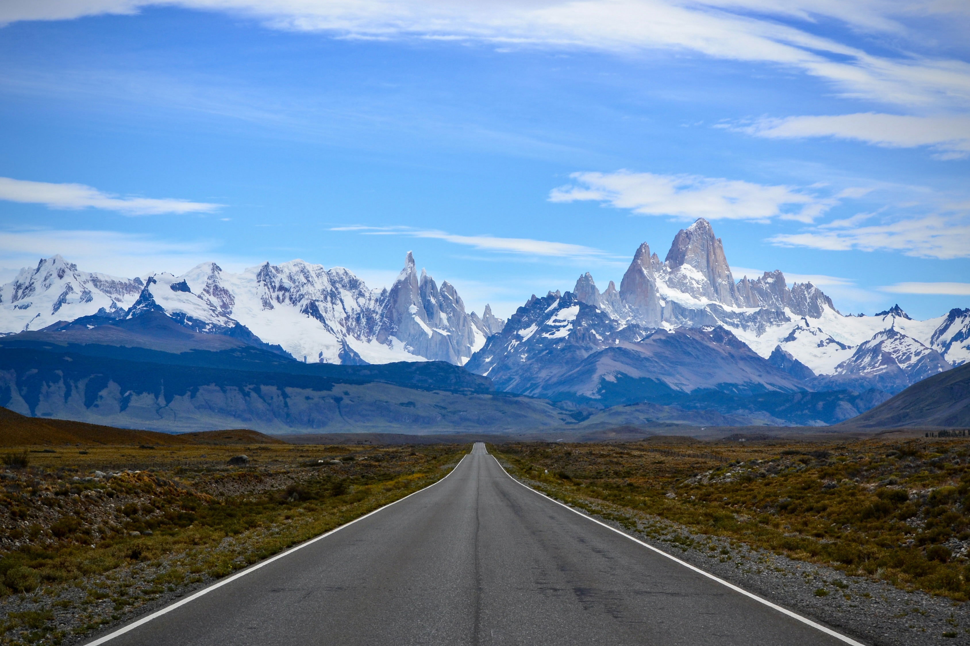 Empty, deserted road to Fitz Roy mountain in the Los Glacieres National Park area. You can see the large, snowcapped mountains in the distance looming over the valley. 