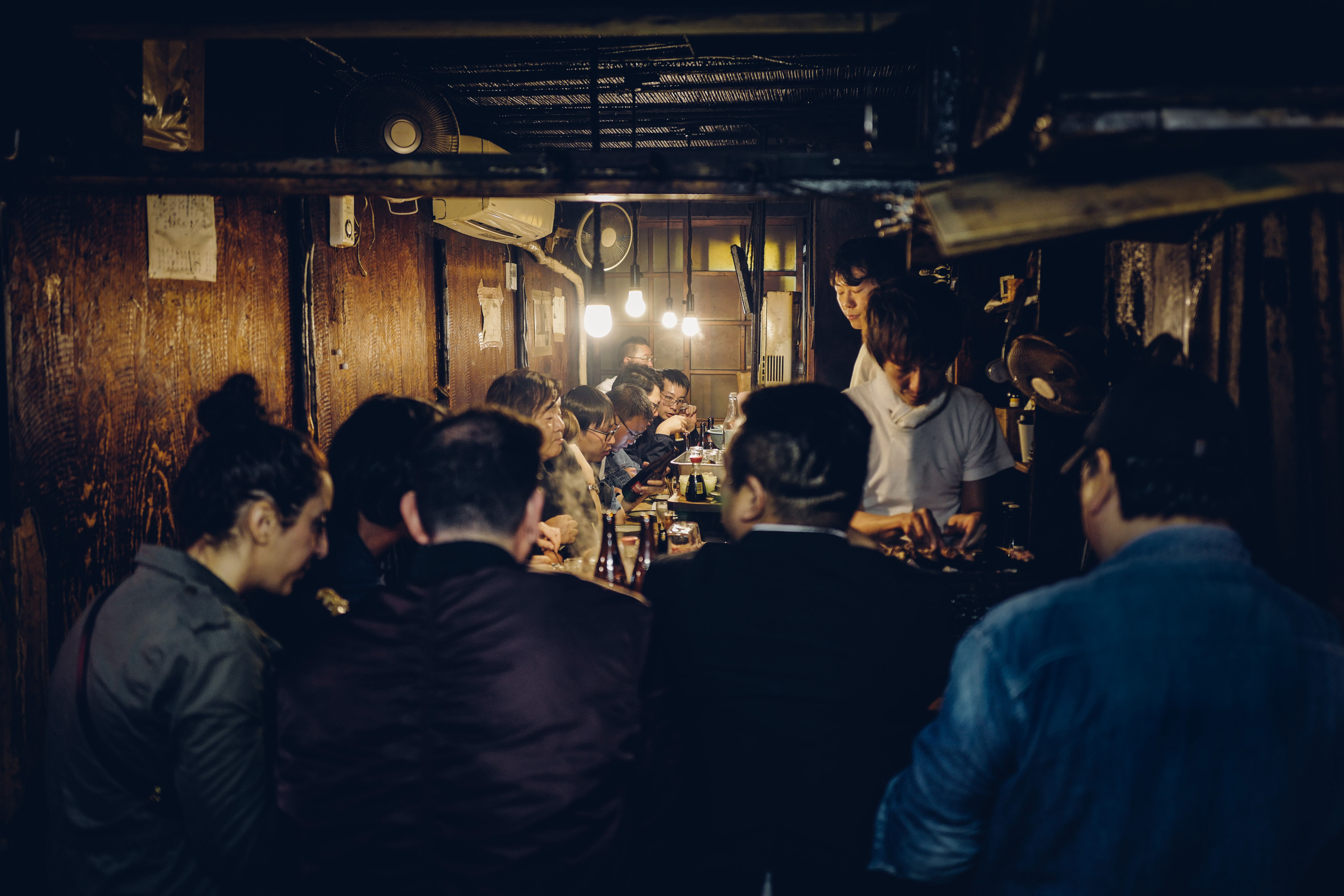 Groep mensen rond verschillende tafels in een Izakaya in Japan